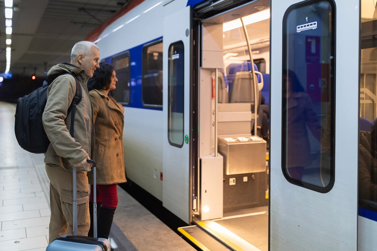 Passengers with luggage waiting on a railway platform